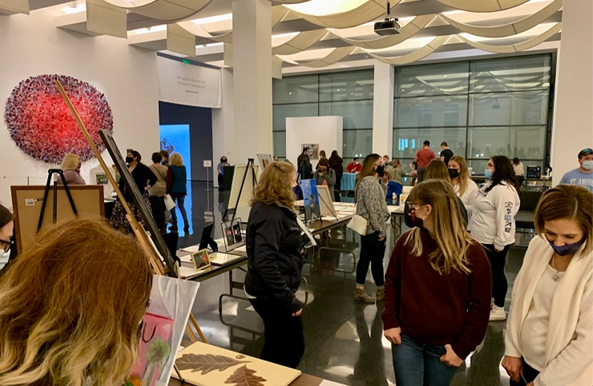 People observe art in a large open room