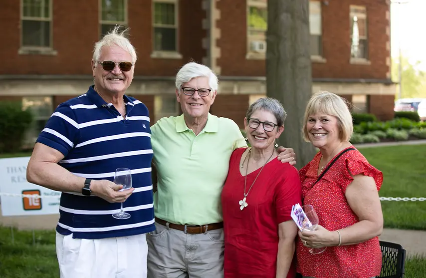 A group of people pose for a photo outside