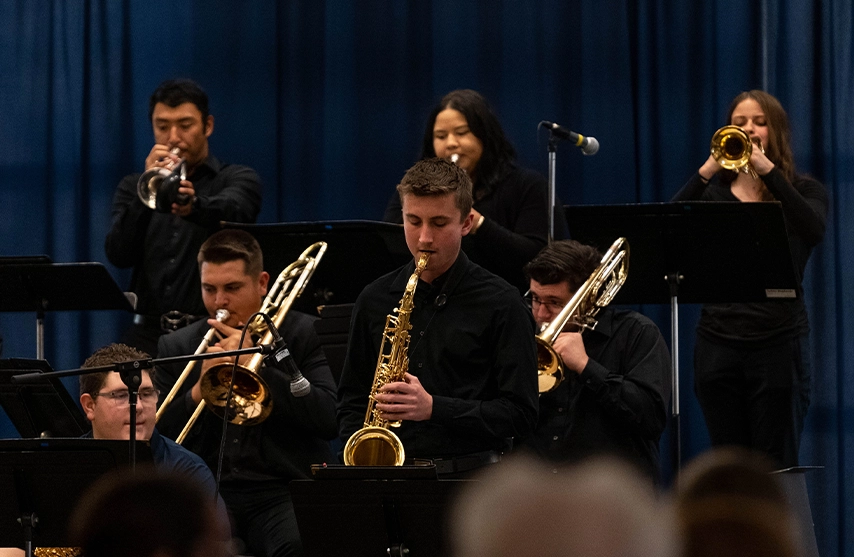 A group of students dressed in black perform a jazz concert on stage.