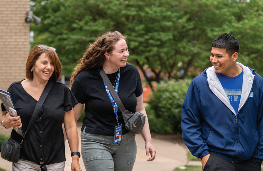 2 students and an adult walking together outside