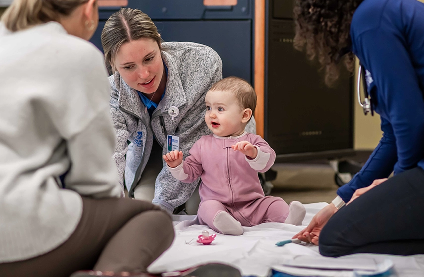 St. Ambrose health sciences students work with a baby during the Baby Lab.
