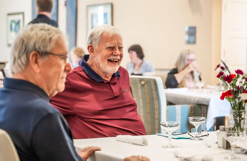 Participants in the RiteCare Clinic fundraiser laugh over dinner.