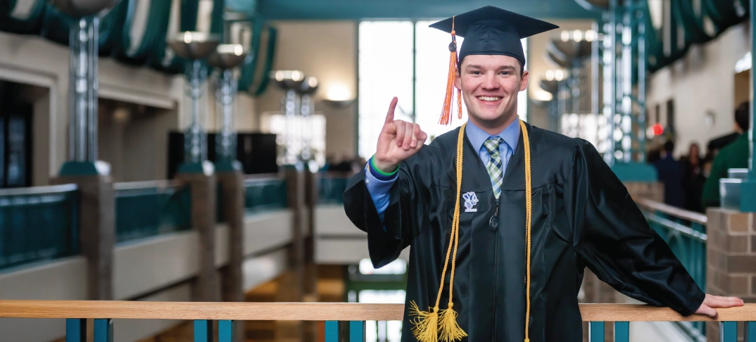Two cheerleaders standing under and umbrella.