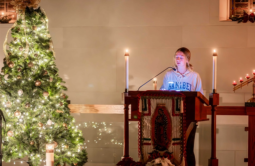 A student reads during Candlelight Mass at St. Ambrose University.
