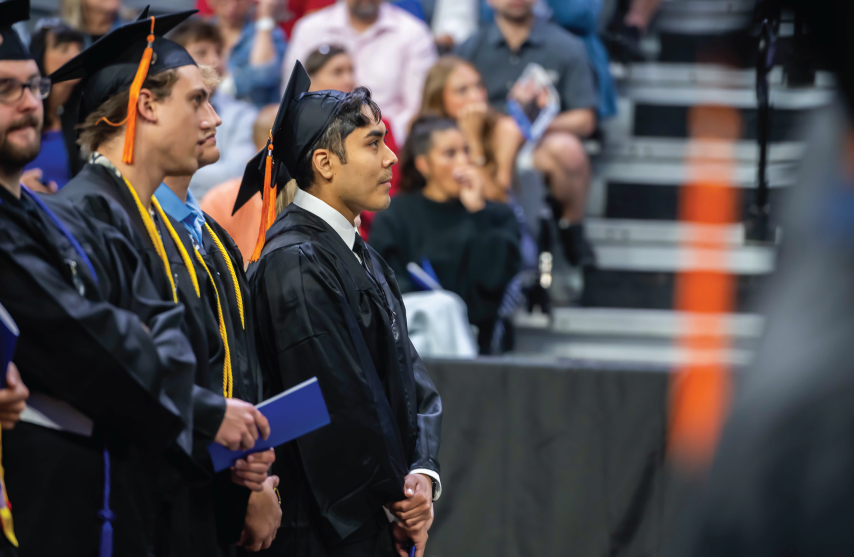 Jair Hernandez standing at commencement.