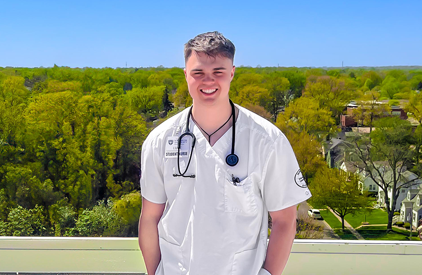Luke Johnson smiles at the camera while wearing a  stethoscope.
