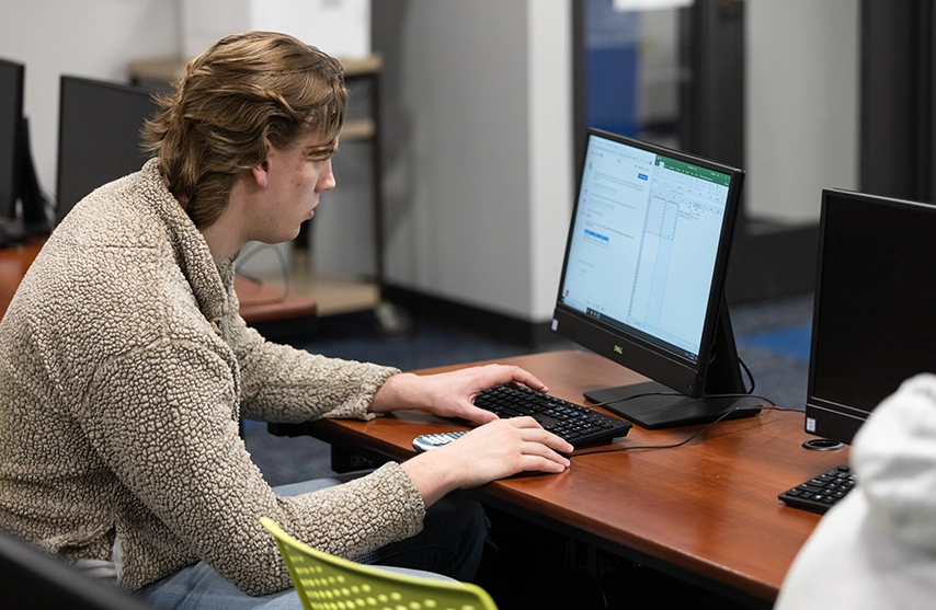 A student works at a computer.