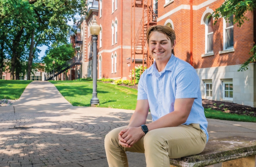 Ryan Russo sits outdoors on a sunny day.