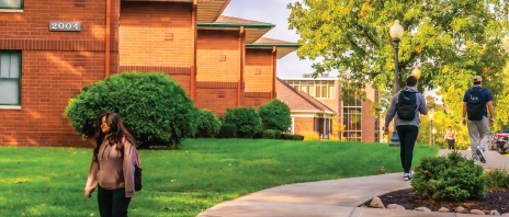 Students walking outside near campus houses.