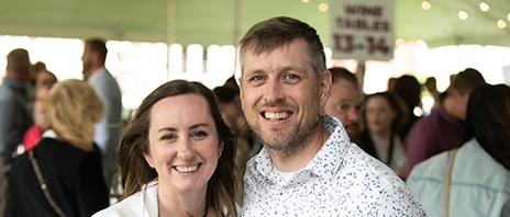 Danielle (Fennelly) ’06 and Kaylon Spengler ‘06 smile into the camera during St. Ambrose University's 2024 Wine Fest.