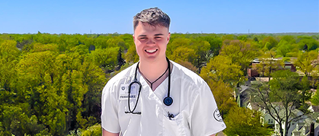 Luke Johnson smiles at the camera while wearing a stethoscope.