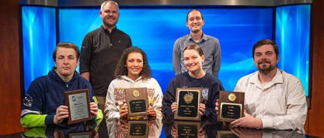 Students and faculty from SAU's multimedia communications program smile as they hold their awards for the 2026 season.