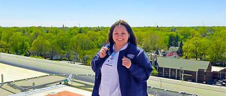 Yazim Morel-Rangel stands in nursing scrubs and smiles at the camera.