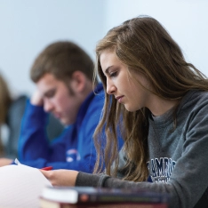 Students reviewing papers in a classroom.