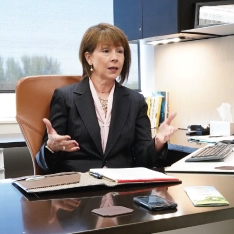 A man and a woman engaged in a professional discussion in an office.