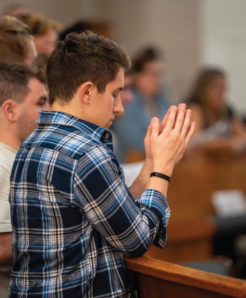 Student praying in Christ the King Chapel.