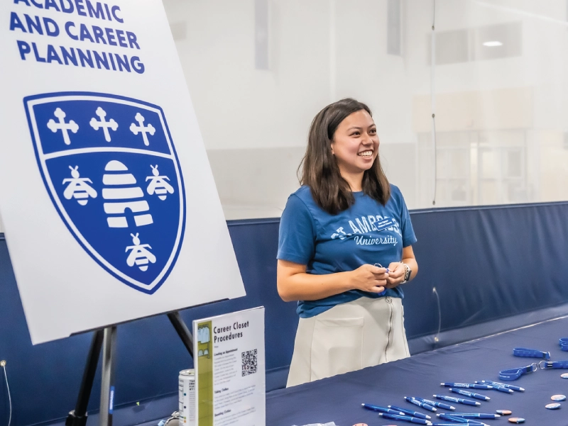 A student standing at a table with a woman at the Career Center.