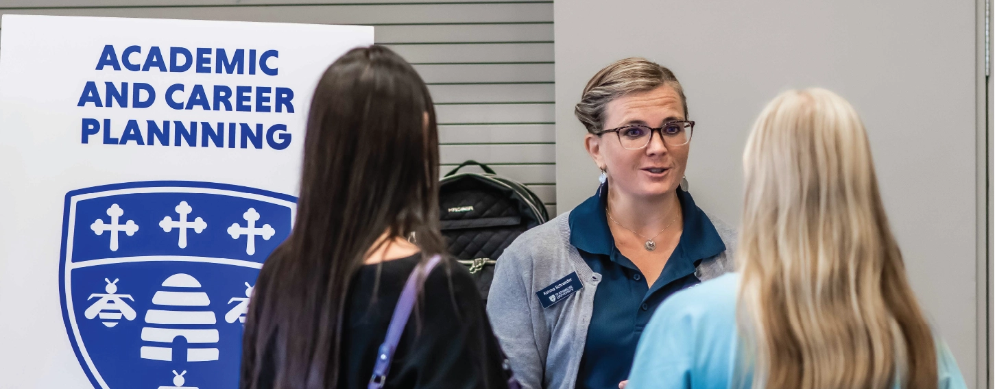 Career center staff talking to students at information fair.