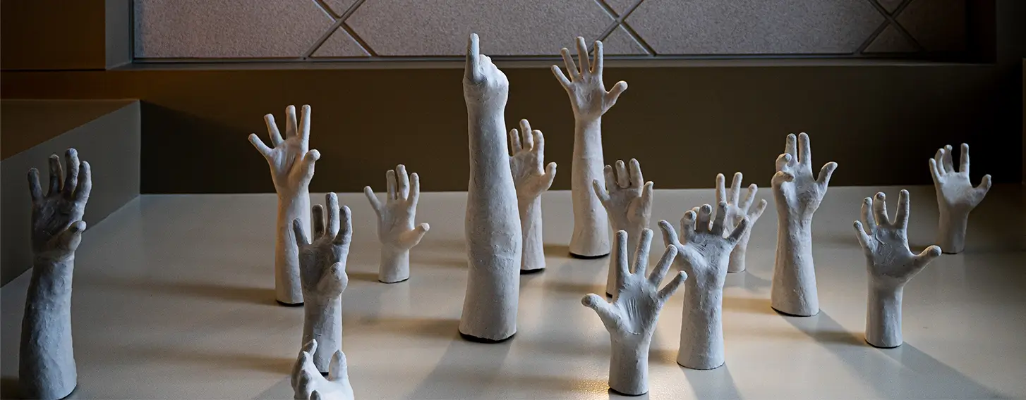 Sculptures of hands reaching up.