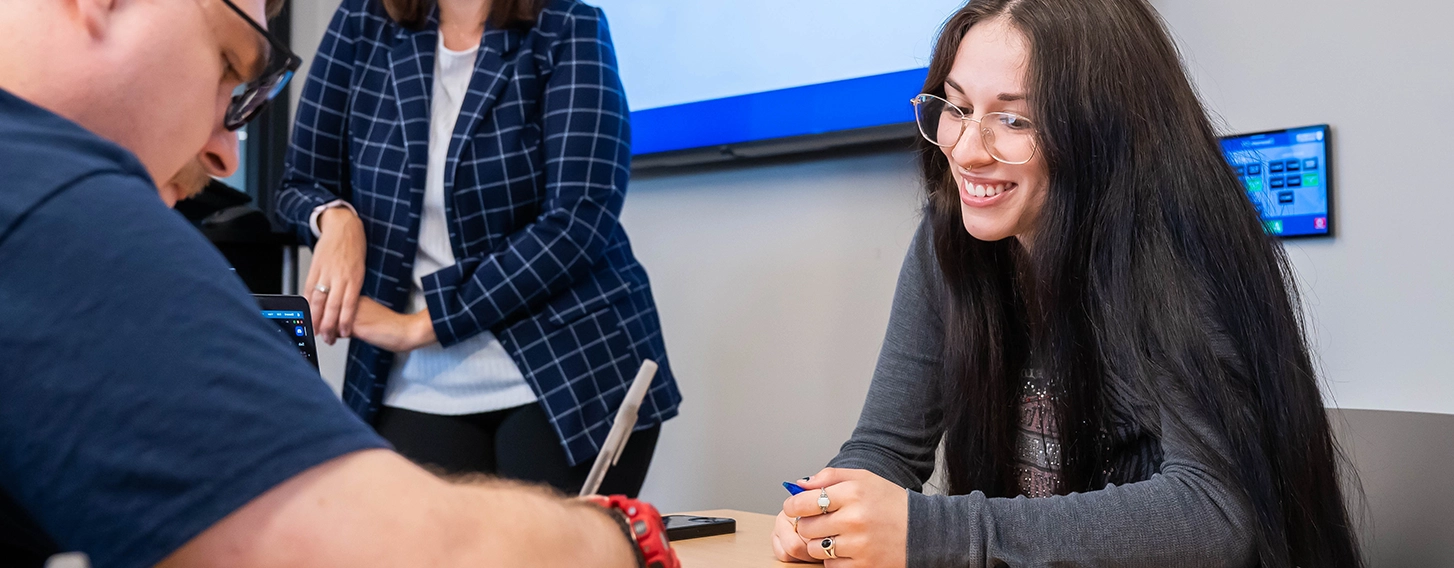 Two students practice under the supervision of their professor at St. Ambrose University.