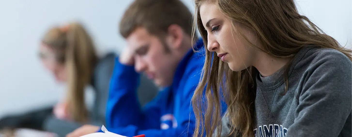 Students reviewing papers in a classroom.