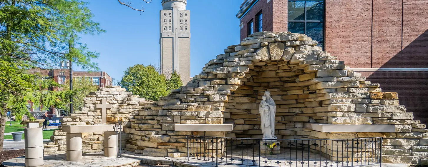 A sculpture underneath a stone grotto on campus.