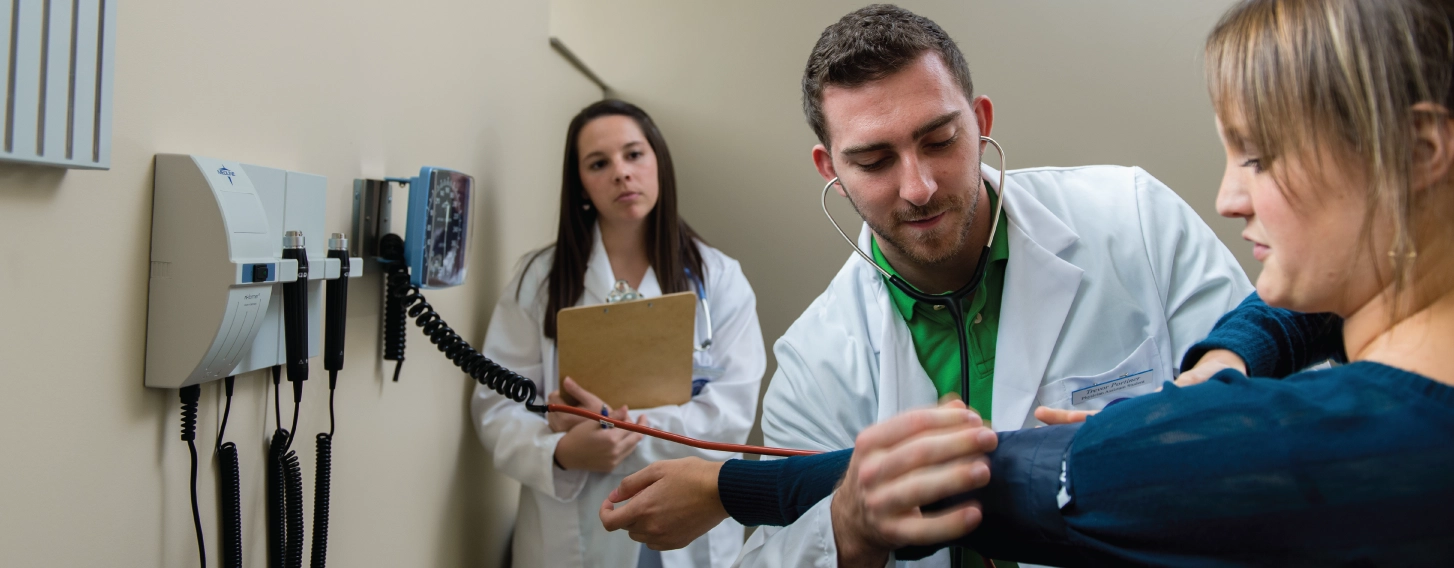 A MPAS student conducting a patient assessment as part of his degree program.