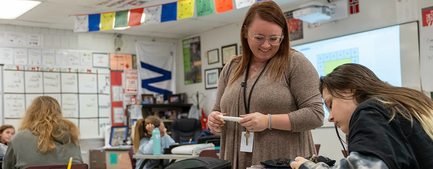 Students receiving guidance in a classroom setting.