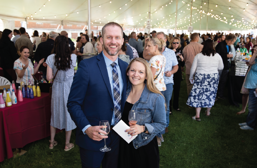 a man and a woman posing for a picture together while holding wine glasses