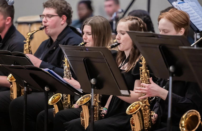 Students at St. Ambrose University play their saxophones during a jazz concert.