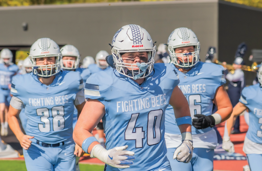 football players in light blue jerseys running on the field
