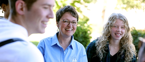 St. Ambrose University President Amy C. Novak, EdD smiles in a group outdoors.