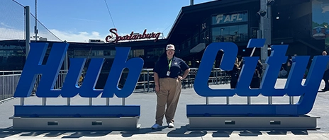 Bailey Conner smiles between two blue signs that read 